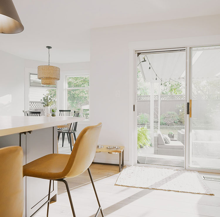Modern white kitchen and dining area with sliding glass doors featuring retractable screens