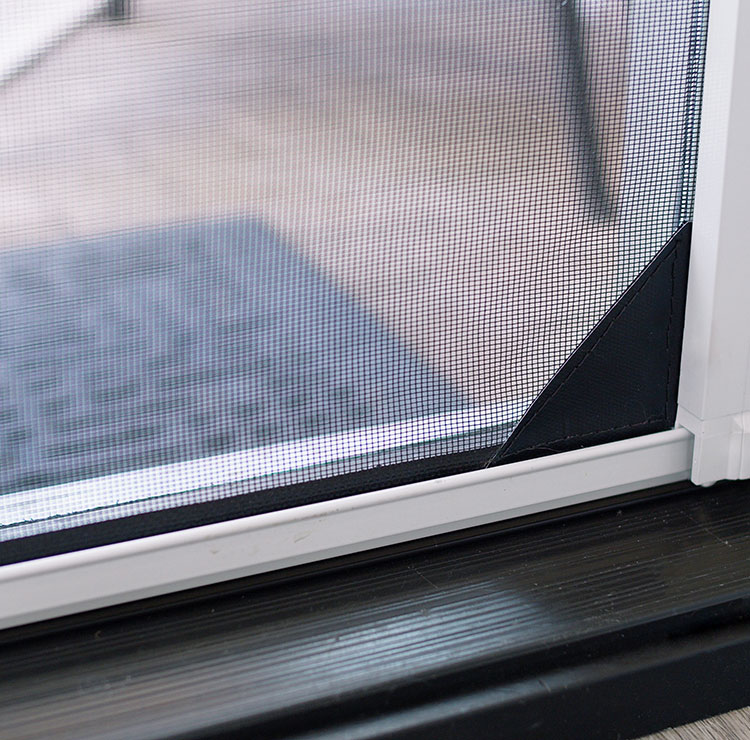 Close-up of retractable screen corner mechanism showing secure mesh lock system