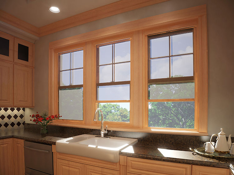 Farmhouse kitchen with triple wood-framed windows above farmhouse sink, featuring diamond-pattern backsplash and natural light streaming in