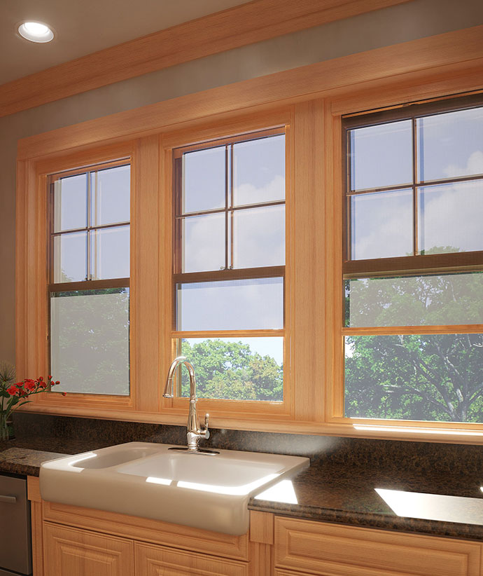 Kitchen with three matching wood-framed windows featuring partially lowered retractable screens above farmhouse sink