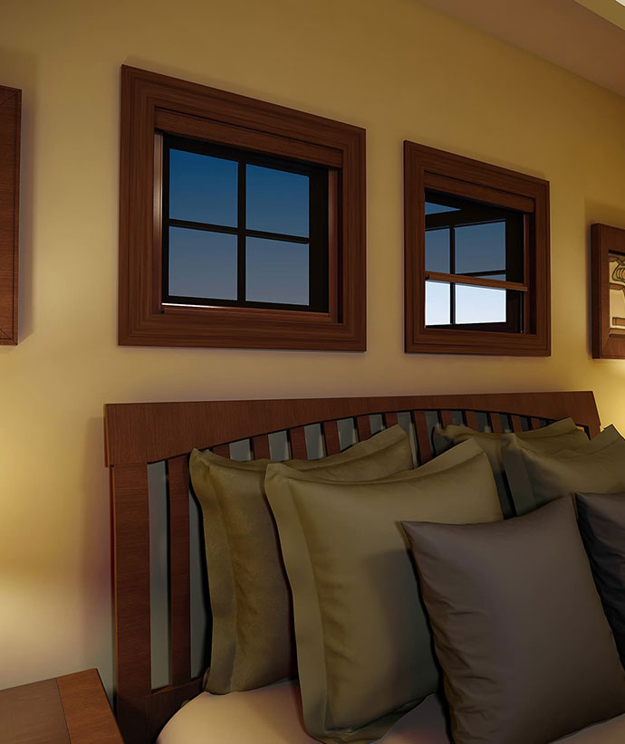 Bedroom windows with dark wood trim and retractable screens, showcasing evening light and pillow-adorned window seat