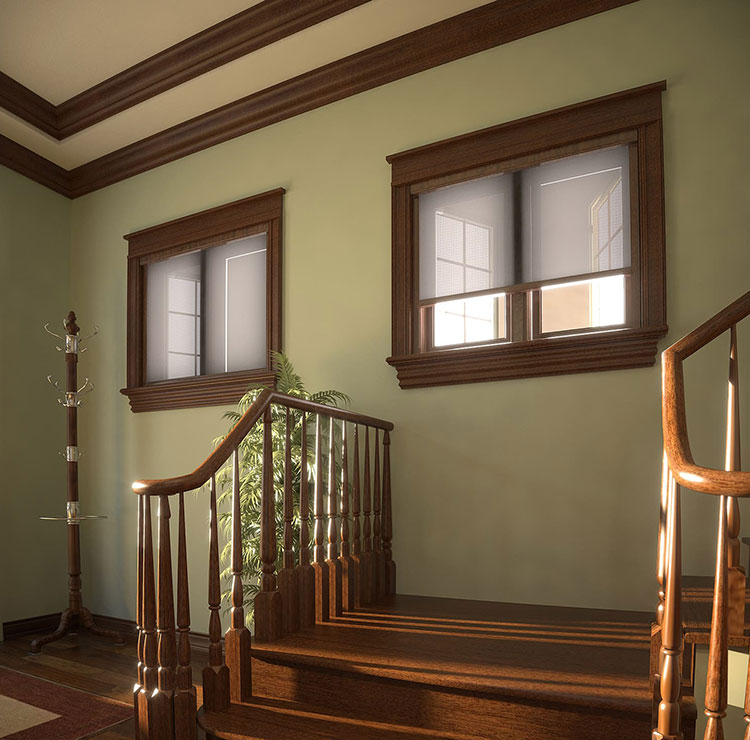 Elegant stairway landing with wood-trimmed windows and retractable screens, highlighting afternoon light through balusters